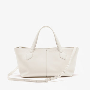 The Proenza Schouler East West Chelsea Tote in white pebbled calf leather features double handles, a detachable shoulder strap, and a structured silhouette, shown against a plain white background.