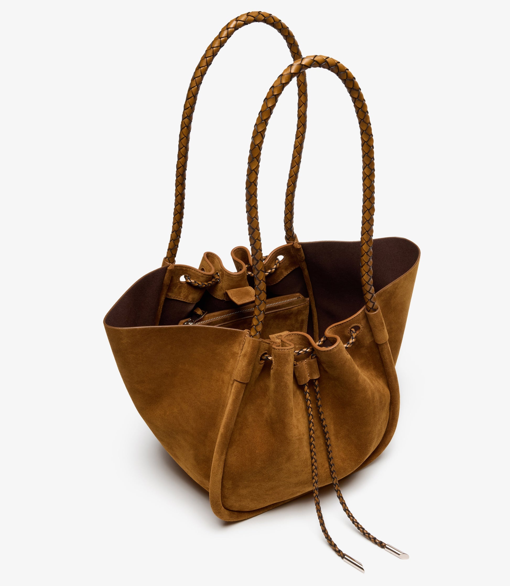 The Proenza Schouler Large Ruched Soft Suede Braided Tote features braided calf handles, a drawstring closure, and an unstructured design, shown here in brown suede on a white background.