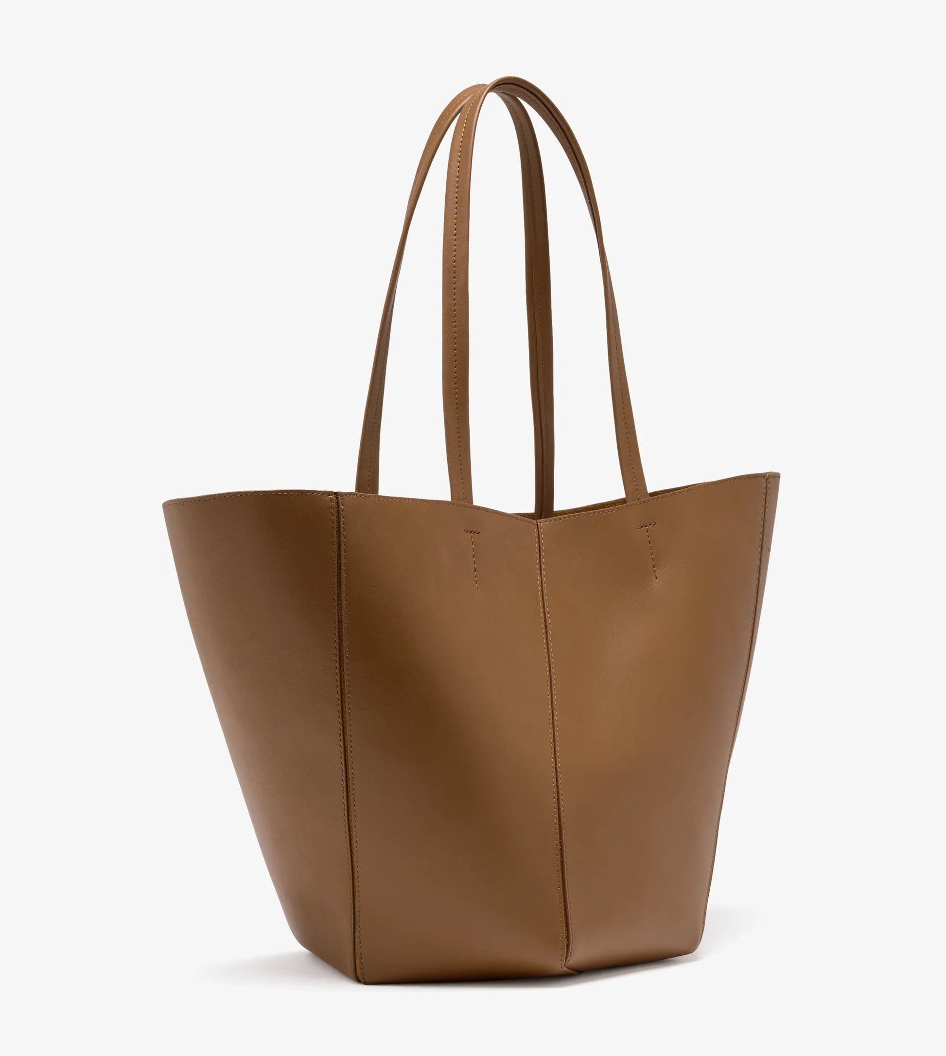 The Hex Tote by Proenza Schouler is a large brown leather bag with two long handles, crafted from smooth calf and shown against a white background.