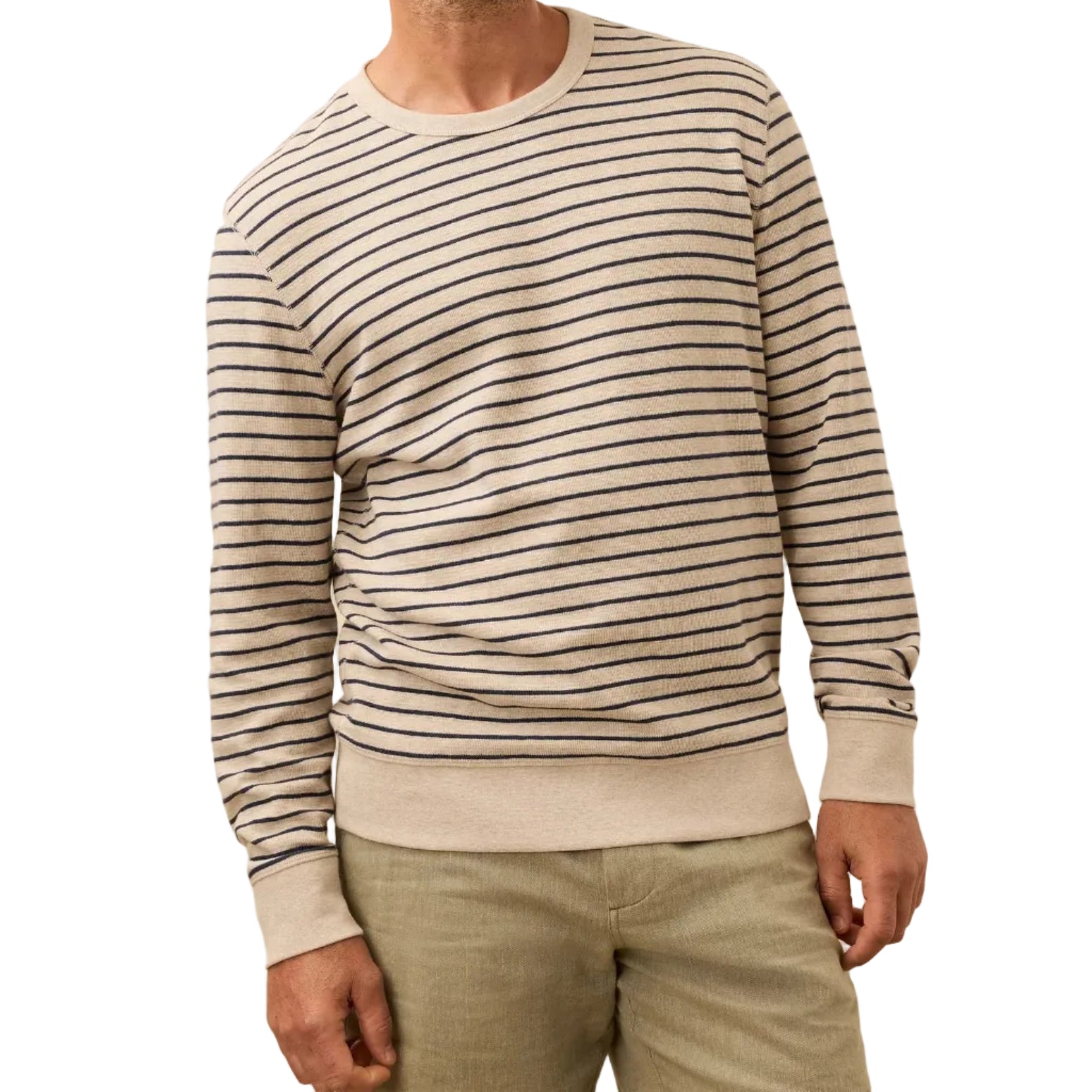 A person wearing the Faherty Double Knit Crewneck in beige with navy stripes and light-colored pants, shown from shoulders to thighs.