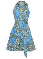 The Cara Cara Hannah Mini Dress features a blue floral halter design with a flared skirt, tiered hem, and tied waist belt. It cleverly combines style and practicality with side seam pockets.