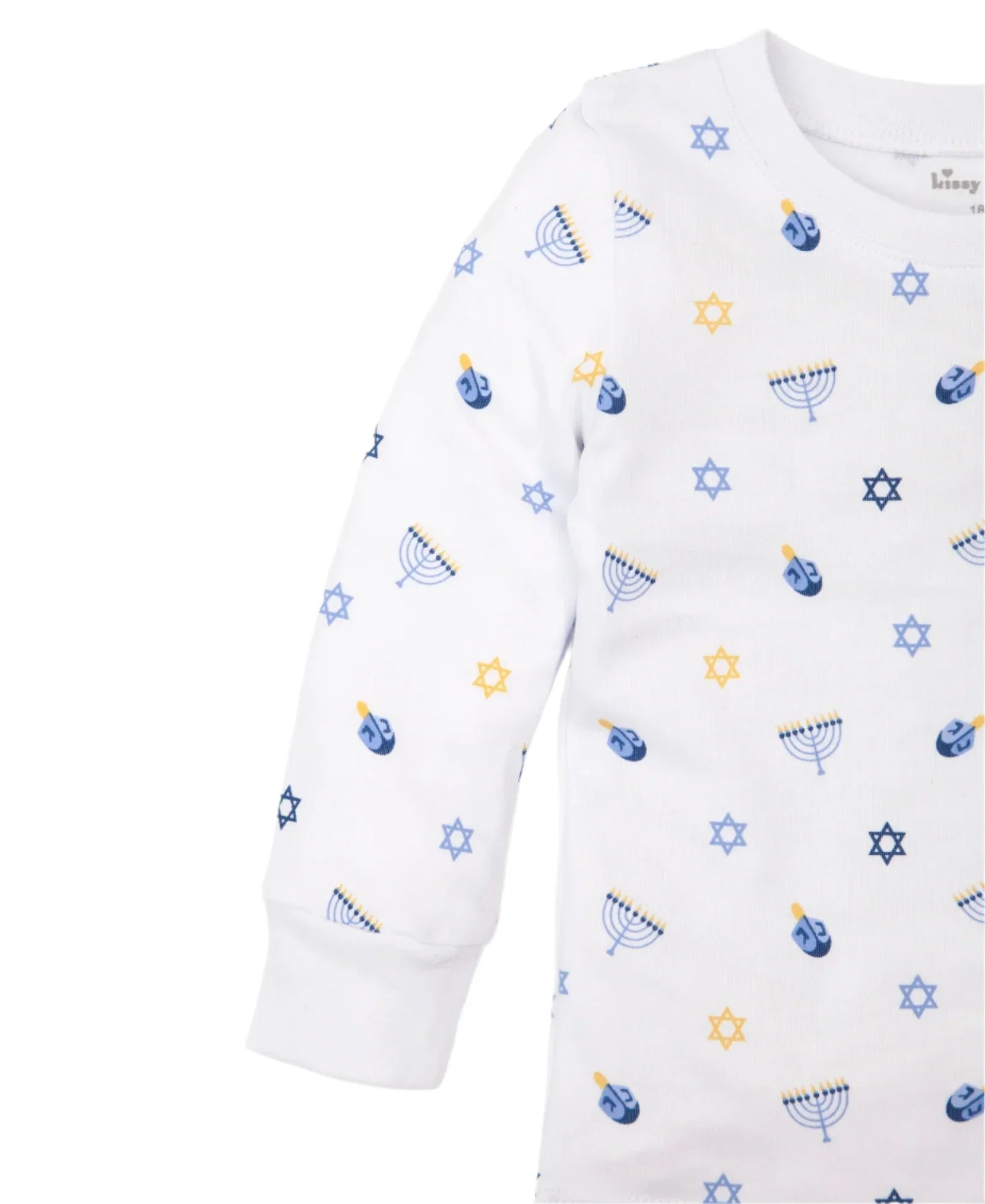 The Kissy Kissy My First Hanukkah Pajama Set by Kissy Kissy is a white long-sleeve Pima cotton shirt adorned with blue and yellow Hanukkah-themed prints, including dreidels, menorahs, and Stars of David. Perfect for festive toddler pajamas.