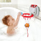 A young child enjoys bath time fun with the Hape Bath Basketball Elephant Pal, aiming a blue ball at the red hoop attached to the tub wall. An orange ball already swishes in the net while the cheerful elephant pal bath toy floats nearby, making playtime even more delightful.