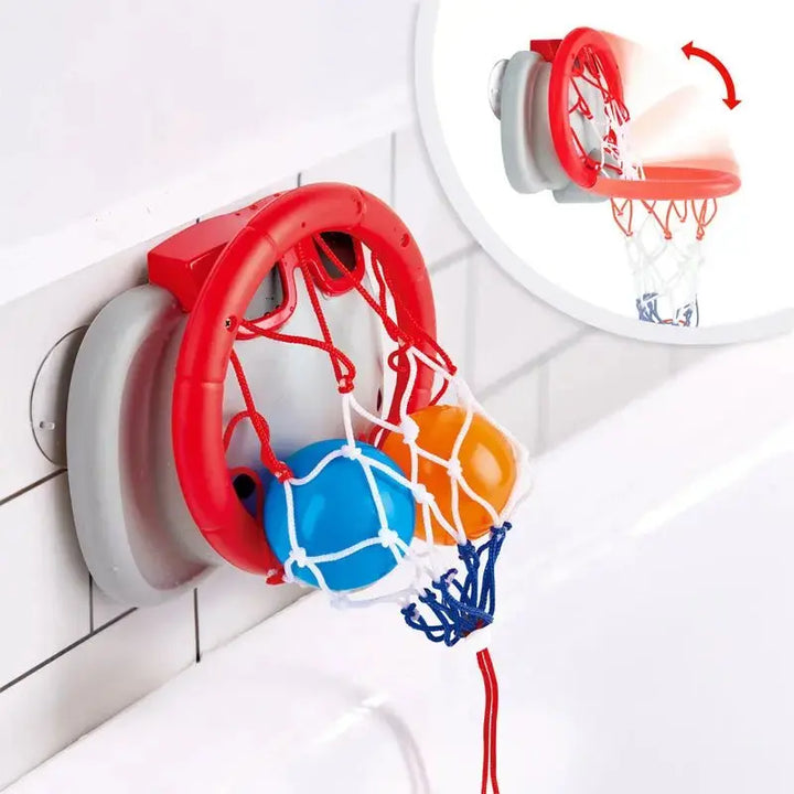 The Hape Bath Basketball Elephant Pal features a red plastic basketball hoop with a white net and two balls, attaching easily to tiled bathroom walls above the bathtub for fun bath time basketball play. An inset shows the hoop folding down, making it a playful addition to any bath toy collection.