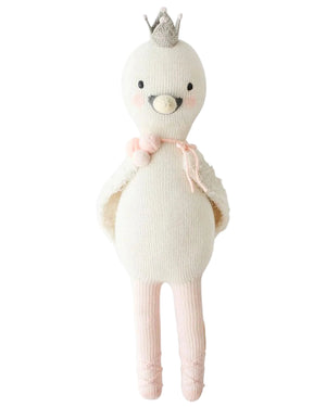 Harlow the Swan - Little 13" by Cuddle + Kind is a knitted white bird doll with brave wings, a silver crown, pink blush, a pink tie at the neck, and pink ballet shoes—ready for dancing adventures.