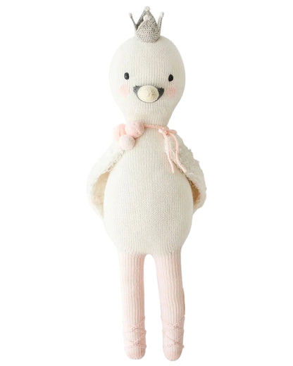 Harlow the Swan - Little 13" by Cuddle + Kind is a knitted white bird doll with brave wings, a silver crown, pink blush, a pink tie at the neck, and pink ballet shoes—ready for dancing adventures.