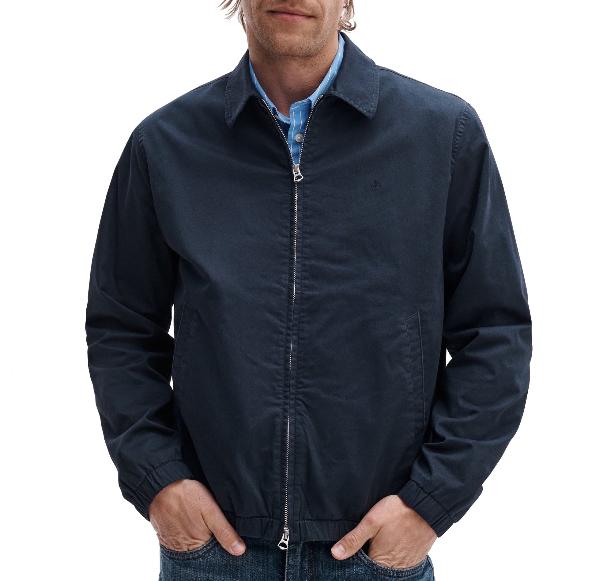 A man in a Rag & Bone Harrington Cotton Jacket, navy blue, over a blue plaid shirt, stands with hands in pockets against a white background.