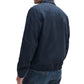A man is shown from the back against a white background, wearing a Rag & Bone Harrington Cotton Jacket and blue jeans.