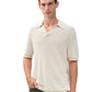 A man wearing the Rag & Bone Harvey Chevron Johnny Polo, a cream-colored lightweight cotton-blend shirt with an open collar, stands with one hand in his pocket against a plain white background.