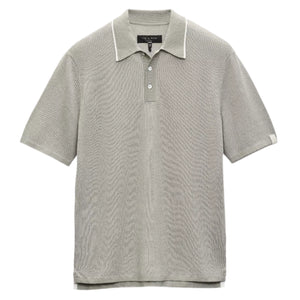 The Harvey Knit Polo Shirt by Rag & Bone is a light gray, short-sleeve polo crafted from a lightweight cotton blend with textured fabric, a three-button placket, and a white label on the left sleeve—ideal for year-round wear.