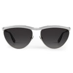 The Krewe Heidi Sunglasses feature vintage-inspired cat-eye silver frames, an architectural metal brow bar, and dark lenses, displayed from the front on a white background.