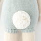 Close-up of Henry the Bunny by Cuddle + Kind, a 20" knitted toy in light blue clothing with a white yarn pom-pom—ready for adventures with best friends.
