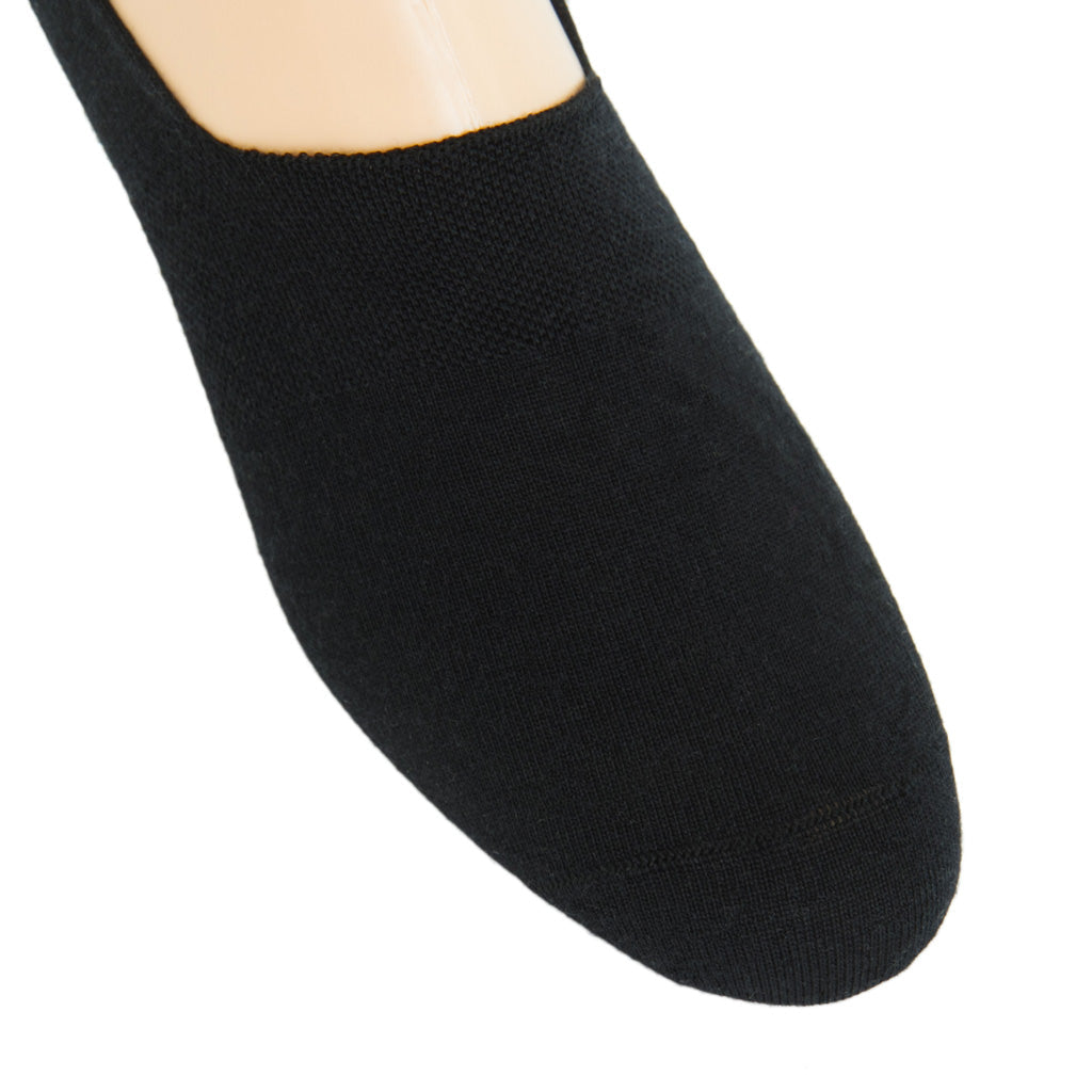 Close-up of a mannequin foot wearing a black flat, crafted from lightweight material with a rounded toe and a textured surface.