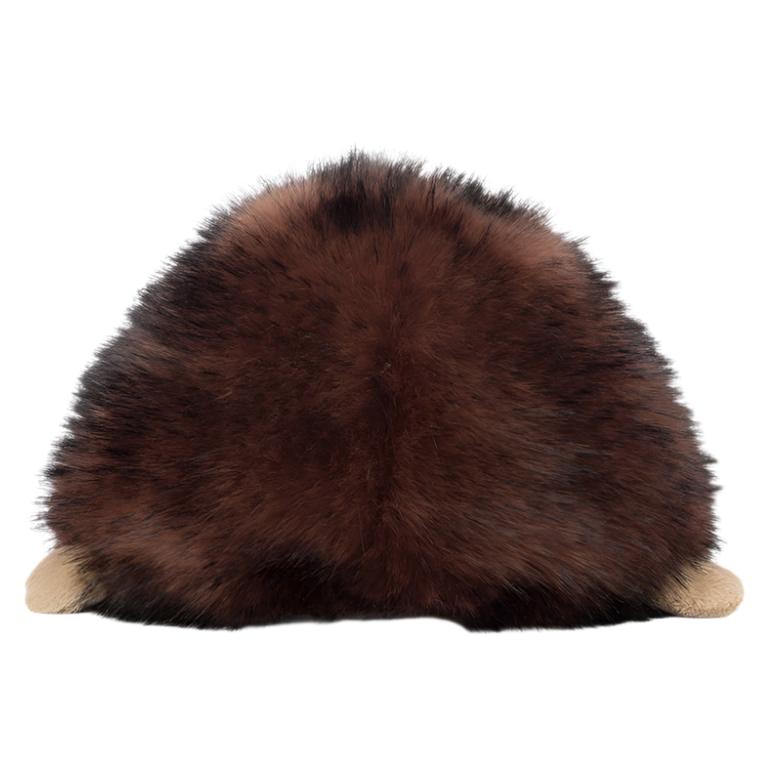 A round, fluffy item resembling the Jellycat Hamish Hedgehog facing away, featuring a silky-soft chocolate ombre surface and small beige protrusions at its base.