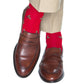 A person wearing beige pants, brown leather loafers, and Dapper Classics Red with Burgundy Berry and Pine Green Holly Wool Sock Linked-Toe Mid-Calf.