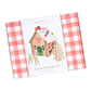 A boxed set labeled "Meri Meri Wooden Embroidery Gingerbread House Kit" from the Meri Meri brand, featuring a red and white checkered pattern on the sides and an image of a wooden house with embroidery decorations on the front, making it a perfect Christmas gift for any creative child.