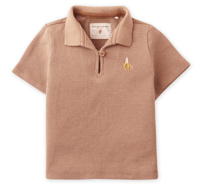 The Gingersnaps Baby Boys' Timmy Waffle Knit Polo Shirt features short sleeves, a light brown color, a collar, and a small embroidered banana logo on the chest—perfect for stylish baby wear.