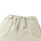 Close-up of Gingersnaps Baby Boys’ Marlow Drawstring Shorts featuring beige textured cotton, an elastic waistband, drawstring tie, and contrast stitching—a comfy pick for casual kids' style.