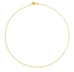 The Anabel Aram Molten Bead Chain Necklace in gold features small, evenly spaced beads along a delicate chain, beautifully displayed in a circular arrangement on a white background.
