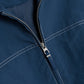 Close-up of the Simkhai Colsen Cotton Cropped Jacket in dark indigo, featuring a silver zipper, boxy silhouette, and white contrast stitching.