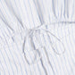 Close-up of the Marcy Cotton Mini Shirt Dress by Simkhai, in white with thin blue stripes and an adjustable drawstring bow at the gathered waist.