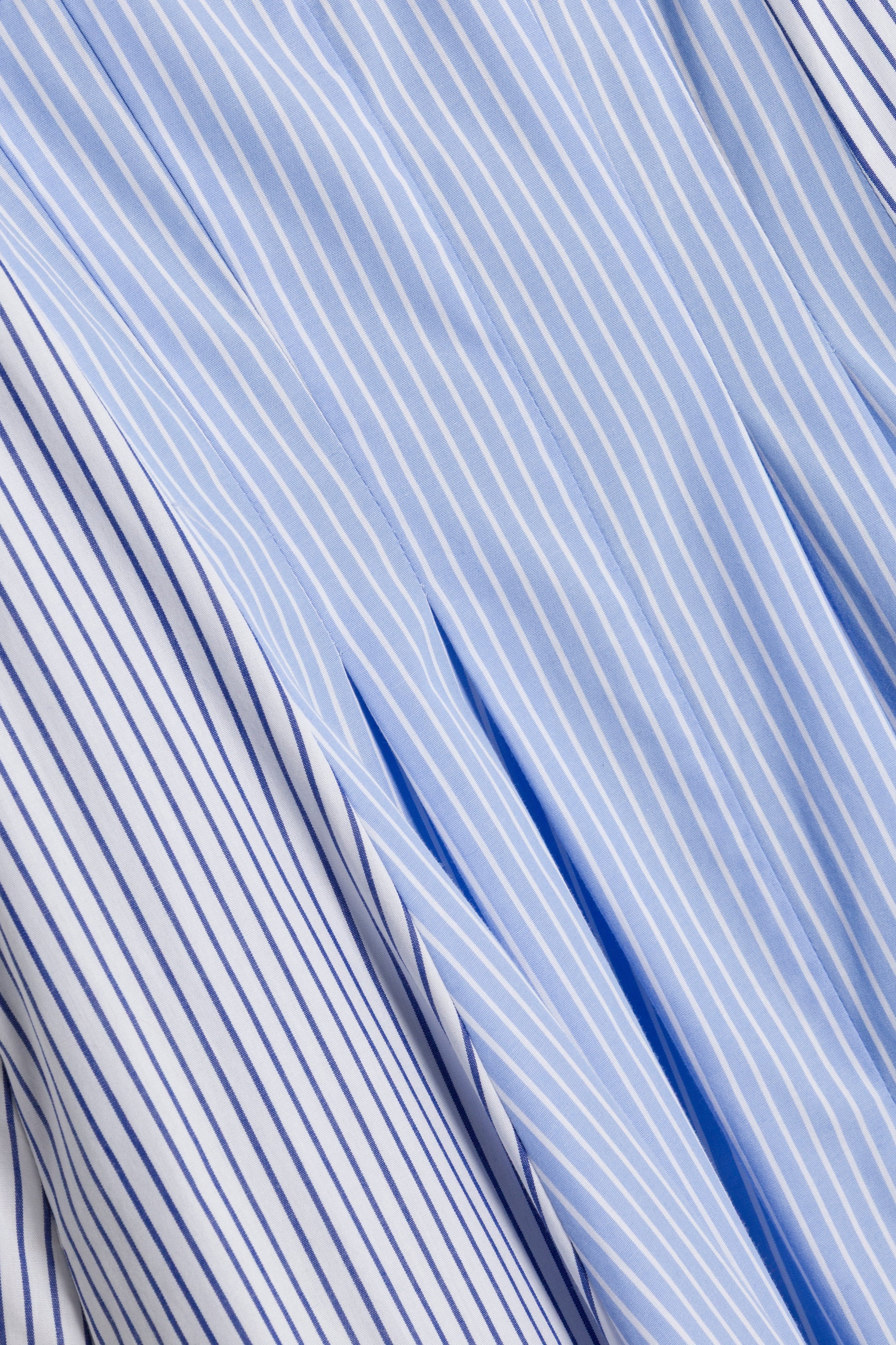 Close-up of periwinkle multi-stripe cotton fabric with thin white and dark blue vertical stripes, showing folds—ideal for the Simkhai Chamberlain Cotton Midi Dress with a cami neckline.