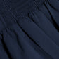 Close-up of the Simkhai Pippa Bubble Mini Skirt in dark blue cotton poplin, featuring a smocked, ruched upper section and a voluminous, pleated lower part.