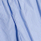 Close-up of Simkhai's Arden Pull On Pant, featuring lightweight light blue cotton with white vertical pinstripes, gathered elastic waistband, and wide leg design.