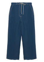 The Simkhai Lennox Cotton Straight Leg Pant features side pockets, white contrast stitching, and an adjustable drawstring waistband, shown in dark indigo against a white background.