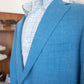 A mannequin wearing a Samuelsohn Bennet Contemporary Fit Blazer over a light blue and white checkered shirt is displayed in a retail setting, showcasing hand-tailored production with exclusive fabrics.