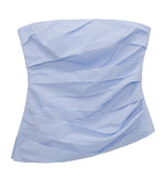 The Emerson Ruched Bustier Top by Simkhai is a strapless, light blue and white striped cotton poplin piece featuring a ruched bustier silhouette and asymmetric draping.