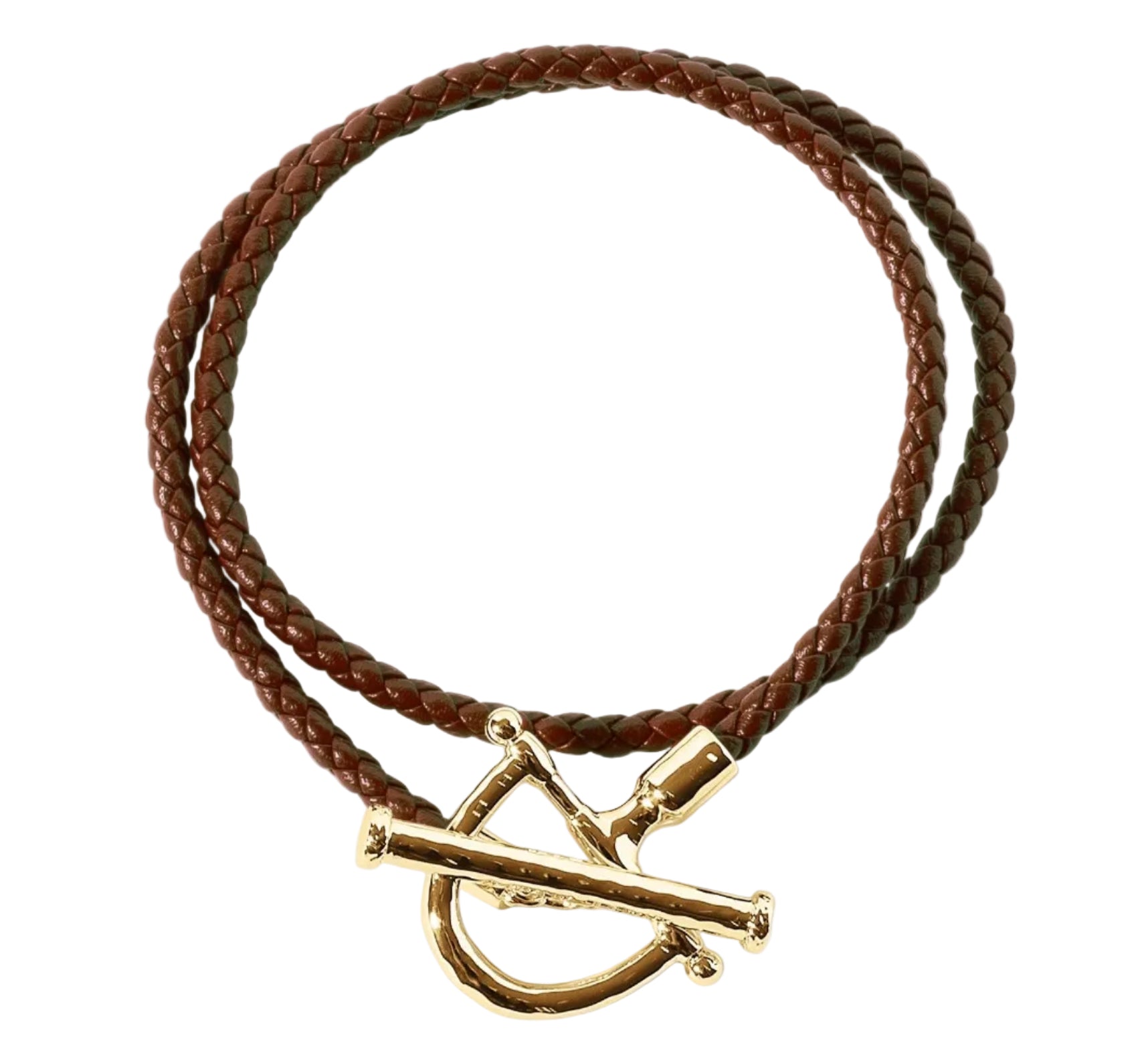 The Cheval Leather Wrap Bracelet by Anabel Aram features brown braided leather and a gold-tone toggle clasp, coiled in a circle on a white background. This equestrian-inspired piece is perfect for effortless everyday style.
