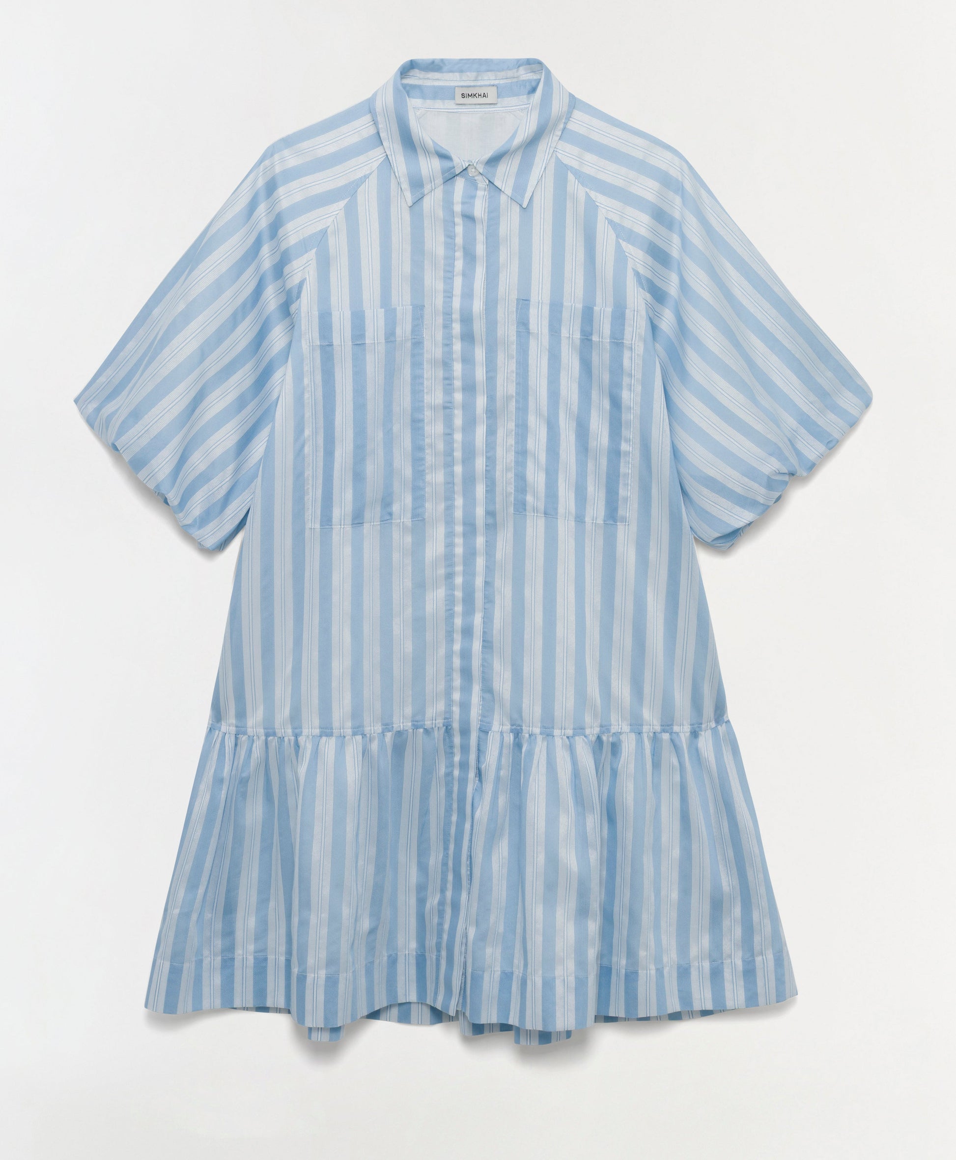 The Crissy Stripe Dress by Simkhai is a light blue and white mini shirtdress with a collar, front buttons, and a gathered flared skirt, crafted from yarn-dyed satin for a soft sheen.
