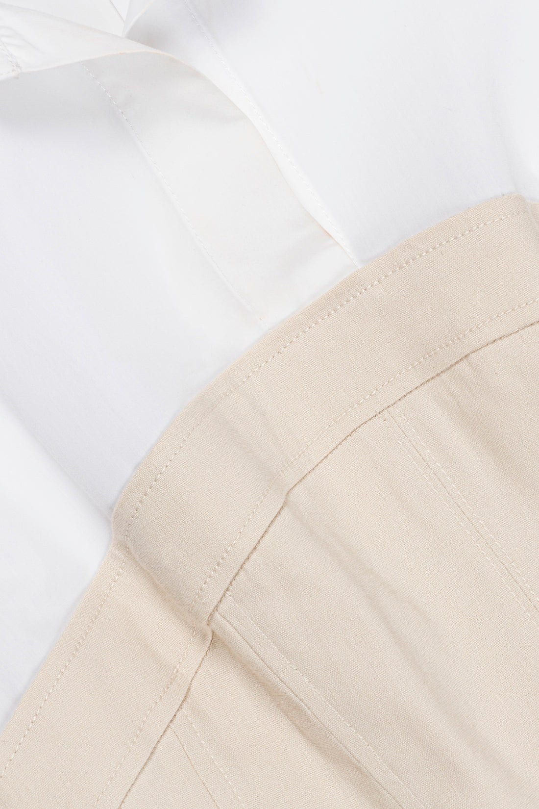 Close-up of the Simkhai Sundae Linen Mini Dress in white, featuring a collared neckline and structured beige bodice with visible seams.