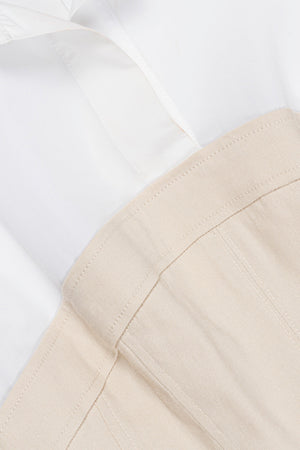 Close-up of the Simkhai Sundae Linen Mini Dress in white, featuring a collared neckline and structured beige bodice with visible seams.