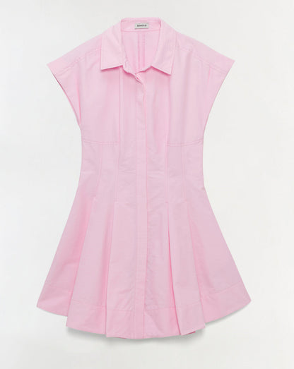 The Clemmie Mini Dress by Simkhai is a light pink cotton mini dress with a collared neckline, short sleeves, and a flared pleated skirt with a concealed button-down front, shown against a plain white background.
