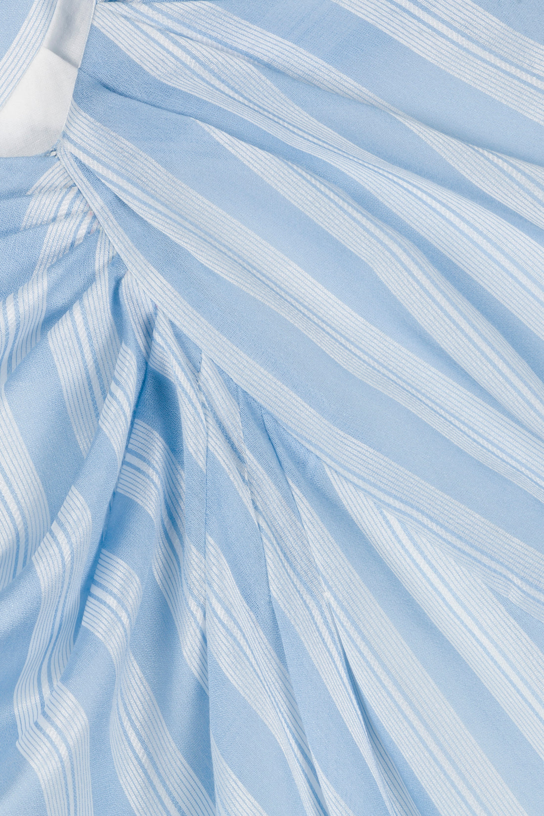 Close-up of the Simkhai Liorra Draped Midi Skirt in oxford blue with light blue and white stripes, showcasing gathered and pleated details that emphasize its wrap-effect design, texture, and pattern.