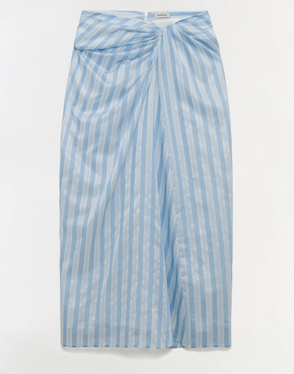 The Simkhai Liorra Draped Midi Skirt features light blue and white stripes, a wrap-effect front, and a concealed back zipper, shown laid flat on a white background.