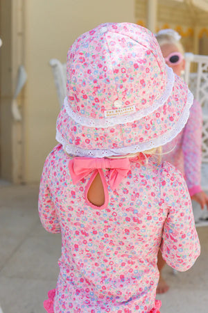 A young child wearing The Beaufort Bonnet Company Baby Girls' Beaufort Bucket Hat stands facing away from the camera.