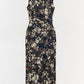 The Simkhai Acacia Jersey Midi Dress features a sleeveless design with a dark floral print, ruched waist detailing, and a fitted silhouette, shown against a plain white background.