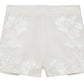 The Sammie Short by Simkhai features a high-waisted fit, floral embroidery on the front, and is crafted from breathable linen for enhanced comfort.