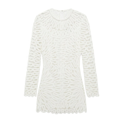 The Simkhai McCall Mini Dress is a long-sleeve white shift dress with textured crochet lace embroidery, a round neckline, scalloped edges, and a chic mini length.