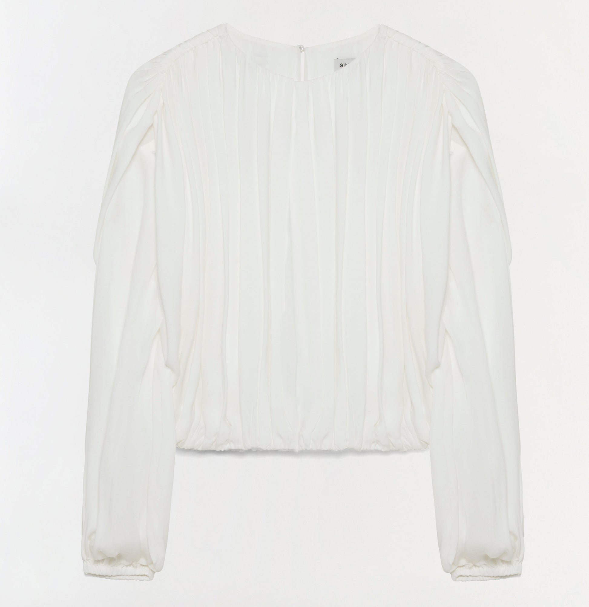 The Simkhai Frida Top is a long-sleeved white silk georgette blouse featuring vertical pleats on the front and subtly gathered blouson sleeves. Displayed against a plain white background, its fluid silhouette brings an elegant touch to any ensemble.
