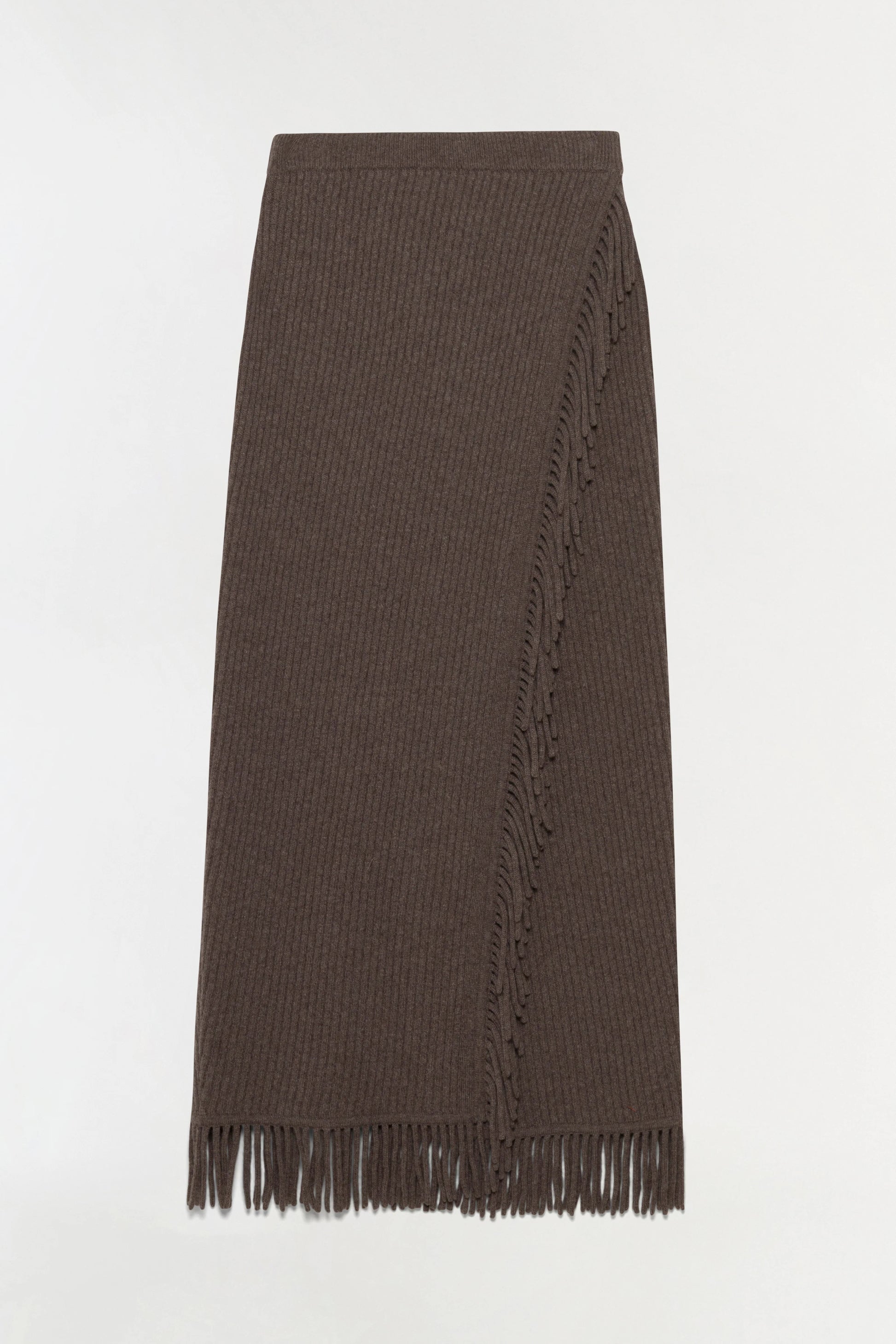 The Casey Knit Skirt by Simkhai is a long, ribbed dark brown midi skirt made from a luxurious wool-cashmere blend, featuring fringe trim along its stylish faux-wrap front and hem, shown against a plain white background.