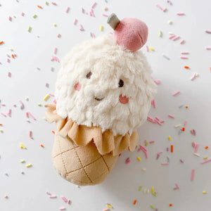 The MON AMI Izzy Ice Cream Chime Toy by Mon Ami is a plush toy designed to resemble an ice cream cone, featuring a cheerful smiley face, a pink cherry on top, and colorful sprinkles against a white backdrop. This sensory toy enchants children with its gentle chime sound, making it an ideal activity toy for babies to enjoy endless playtime fun.