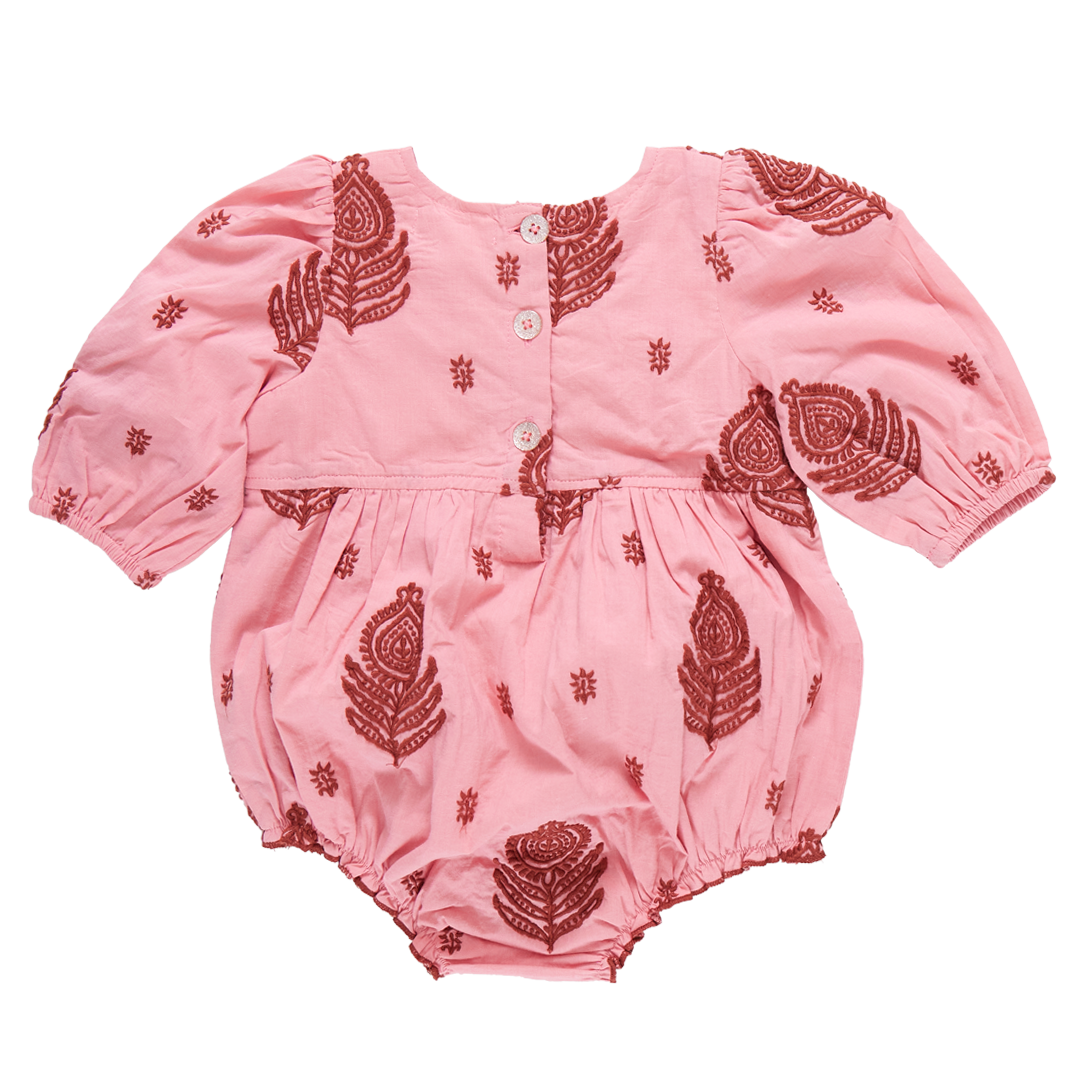 The Pink Chicken Baby Girls' Brooke Embroidered Bubble by Pink Chicken is a pink baby romper crafted from 100% cotton, adorned with all-over Indian embroidery designs in red. It features three front buttons, long sleeves, and elastic cuffs at both the wrists and legs.