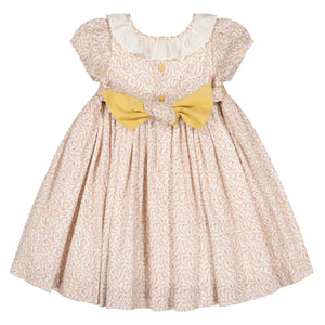 The Antoinette Baby Girls' and Girls' Isadora Short Sleeve Floral Smocked Dress features an elegant floral pattern, white ruffled collar, front buttons, and a large yellow bow at the waist.