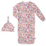 The Magnetic Me Isla Gown and Hat Set by Magnetic Me is an eco-friendly TENCEL™ newborn sleeper gown with matching knotted hat, featuring magnetic closures and a vibrant floral pattern in shades of pink, blue, yellow, and purple.