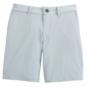 The Boys' Mulligan Jr. Performance Shorts by Johnnie-O are light gray, knee-length, with belt loops, front pockets, and a button closure. Made from stretch fabric for comfort during after-school sports. Shown on a plain white background.
