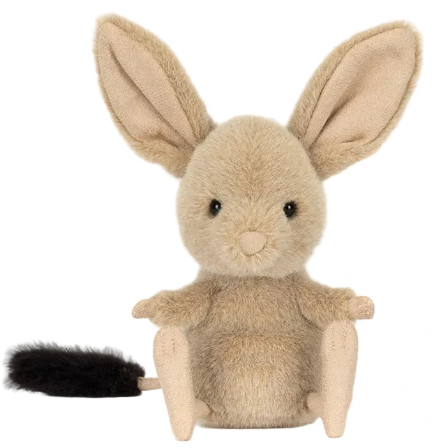 The Jellycat Jerboa plush is a small rodent-like stuffed animal with large ears, beige fur, a round body, and a black-tipped tail, shown sitting upright against a white background.